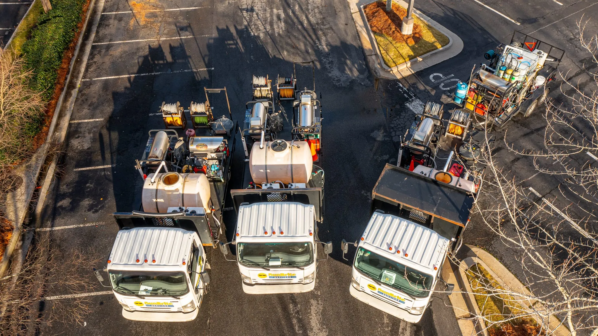 Team of water tank cleaning technicians in protective gear with a pressure washer and hoses